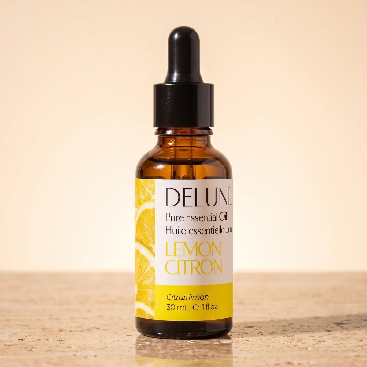 Frasco gotero de vidrio ámbar de 30 ml del Aceite esencial puro de limón amarillo de Delune sobre travertino cálido