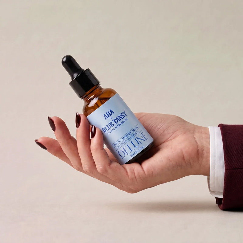 Aceite renovador de noche AHA + tanaceto azul de Delune sobre una mano abierta