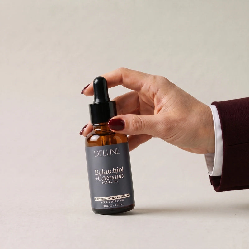Una mano toma el aceite facial de bakuchiol + caléndula de Delune