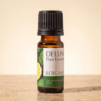 Frasco de vidrio ámbar de 10 ml de aceite esencial puro de bergamota de Delune sobre piedra travertino cálida