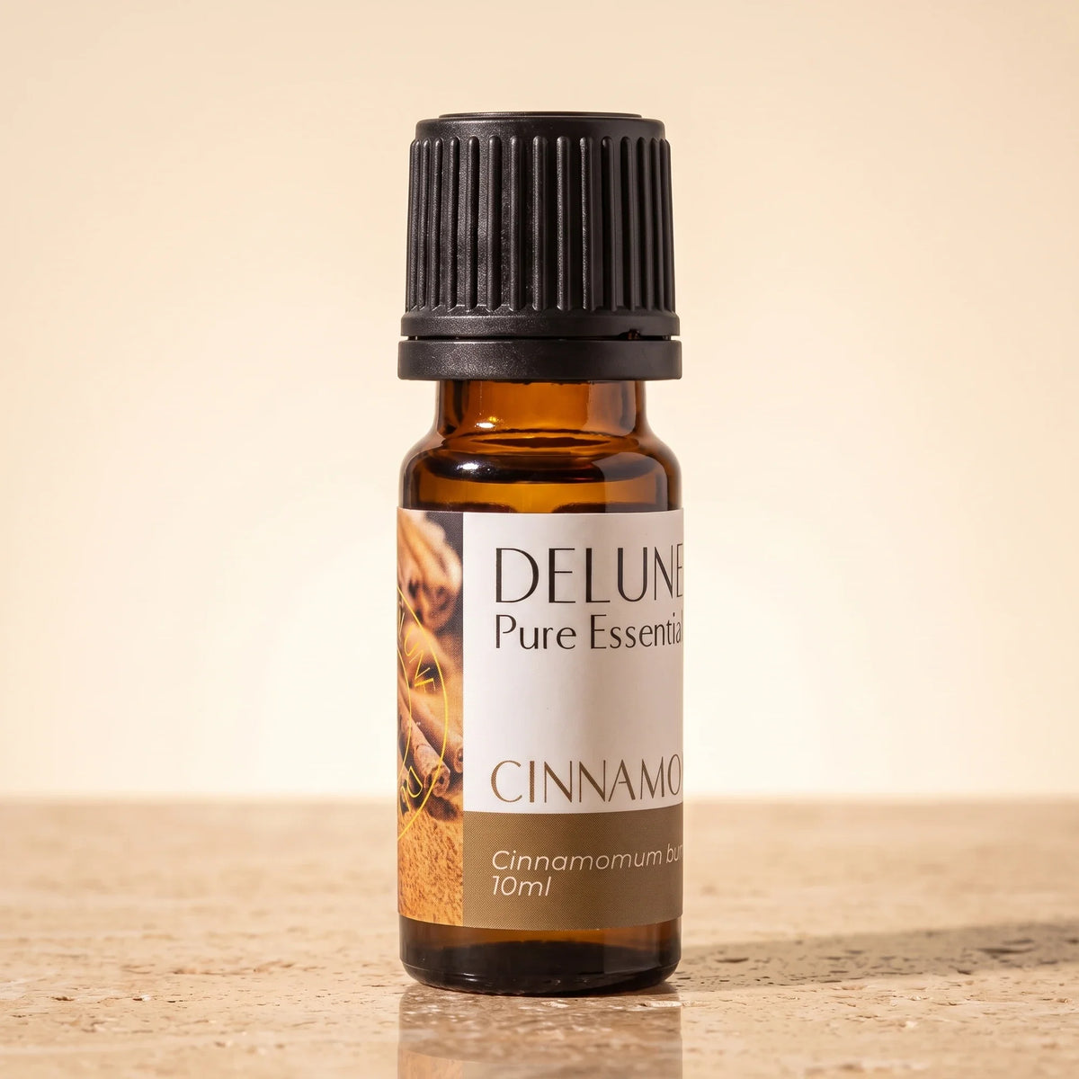 Frasco de vidrio ámbar de 10 ml de aceite esencial puro de canela de Delune sobre piedra travertino cálida