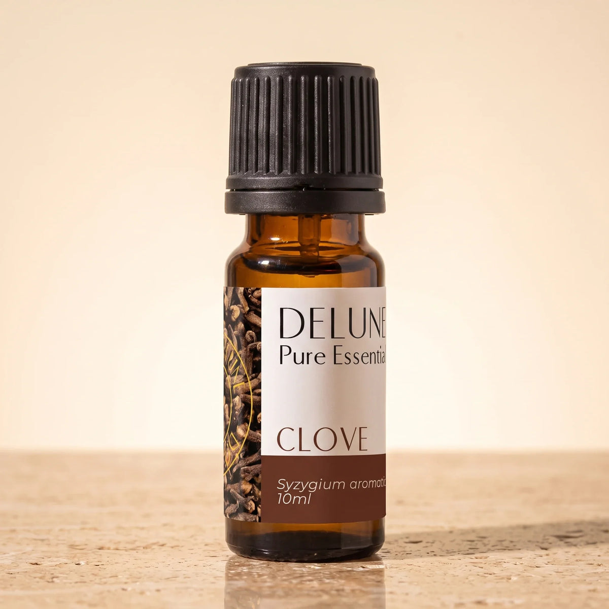 Frasco de vidrio ámbar de 10 ml de aceite esencial puro de clavo de Delune sobre piedra travertino cálida