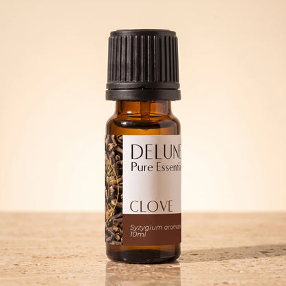 Frasco de vidrio ámbar de 10 ml de aceite esencial puro de clavo de Delune sobre piedra travertino cálida