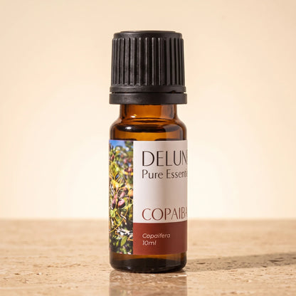 Frasco de vidrio ámbar de 10 ml de aceite esencial puro de copaíba de Delune sobre piedra travertino cálida