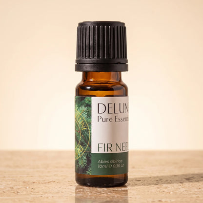 Frasco de vidrio ámbar de 10 ml del aceite esencial puro de agujas de abeto de Delune sobre piedra travertino cálida