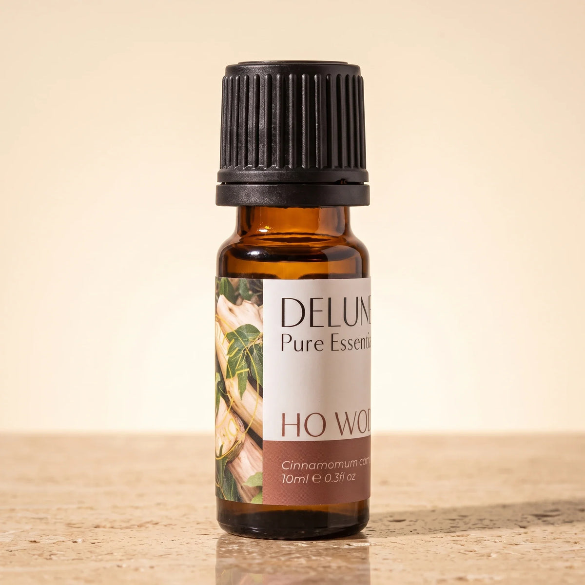 Frasco de vidrio ámbar de 10 ml del Aceite esencial puro de madera de ho de Delune sobre travertino cálido