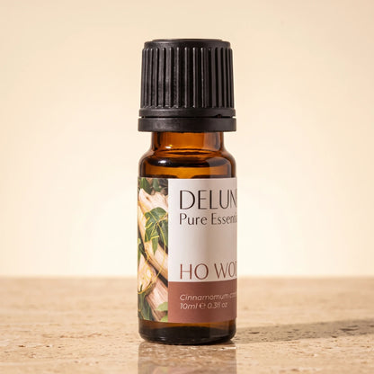 Frasco de vidrio ámbar de 10 ml del Aceite esencial puro de madera de ho de Delune sobre travertino cálido