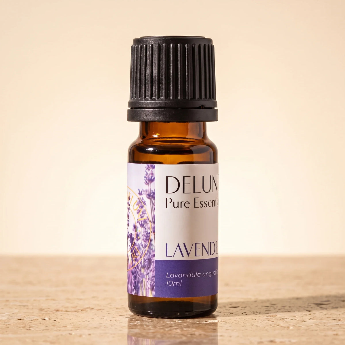 Frasco de vidrio ámbar de 10 ml del Aceite esencial puro de lavanda (francesa) de Delune sobre travertino cálido