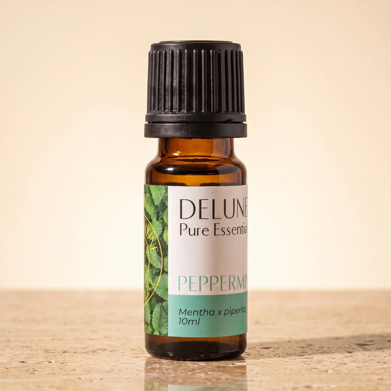 Aceite esencial puro de menta de Delune en frasco de vidrio ámbar de 10 ml sobre piedra travertino cálida