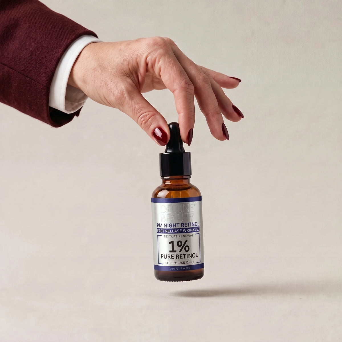 Una mano levanta el sérum de noche con retinol PM Night Power de Delune Beauty