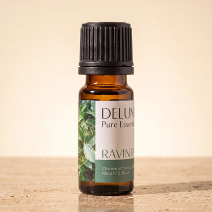 Aceite esencial puro de ravintsara Delune, frasco de vidrio ámbar de 10 ml sobre piedra travertino cálida