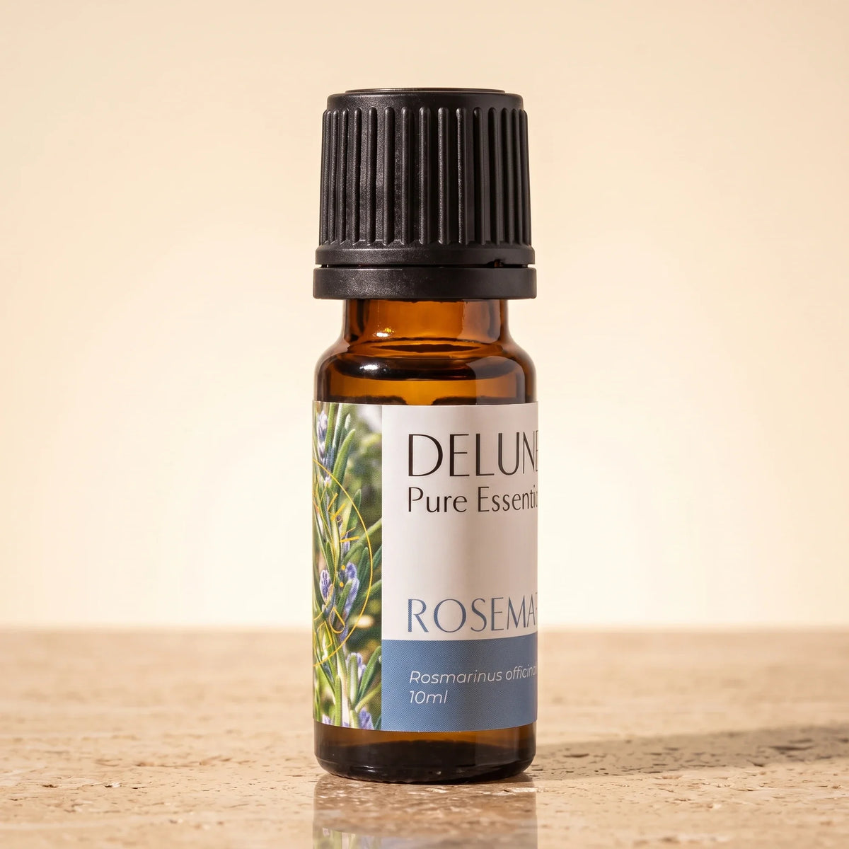 Aceite esencial puro de romero Delune, frasco de vidrio ámbar de 10 ml sobre piedra travertino cálida