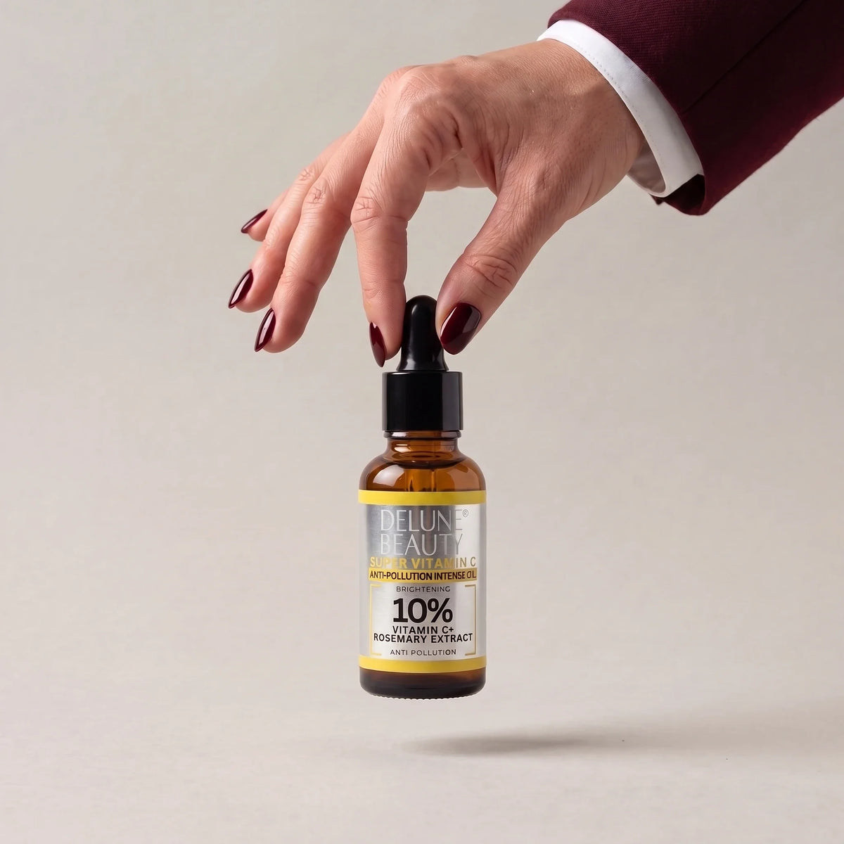 Una mano levanta el aceite iluminador Super Vitamin C de Delune