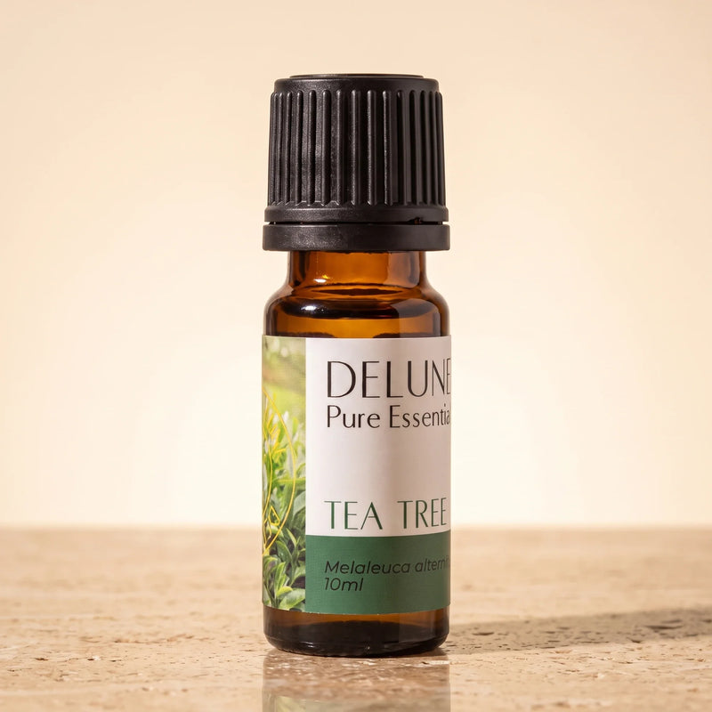 Aceite esencial puro de árbol de té de Delune, frasco de vidrio ámbar de 10 ml sobre piedra travertino cálida